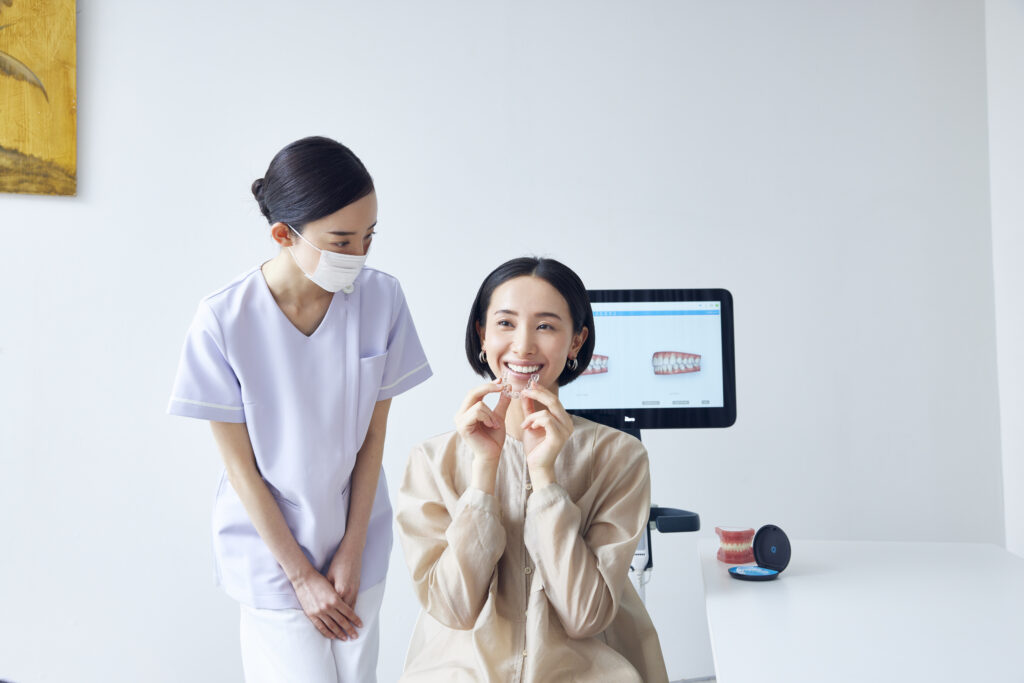歯科衛生士とインビザラインを装着する女性